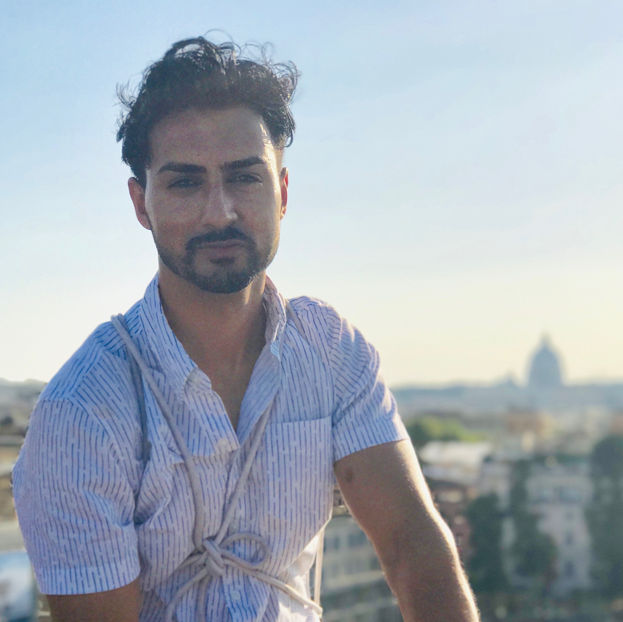 Zeeshan sitting on a ledge looking over Rome, Italy